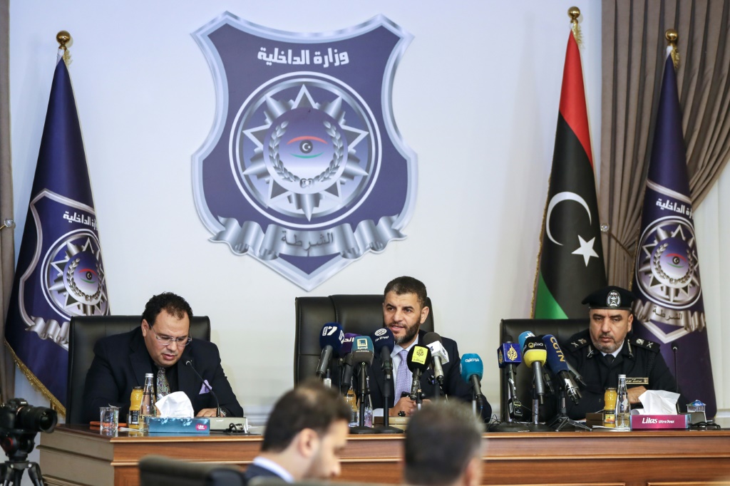 وزير الداخلية الليبي بالإنابة عماد الطرابلسي (وسط) يتحدث خلال مؤتمر حول برامج الهجرة والعودة الطوعية، بحضور سفراء أجانب وممثلين عن المنظمات الدولية، بمقر وزارة الداخلية في العاصمة طرابلس في 2 كانون الأول/ديسمبر 2025 (ا ف ب)