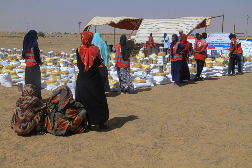 نساء سودانيات نزحن من مدينةالفاشر ينتظرن الحصول على مساعدات إنسانية في مخيم العفاض للنازحين في الدبة بشمال السودان في 25 تشرين الثاني/نوفمبر 2025 (ا ف ب)