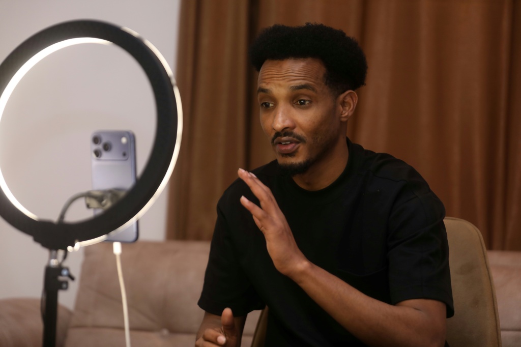 مهاد محمود يتفاعل مع متابعيه أثناء بث مباشر على وسائل التواصل الاجتماعي في مقديشو في 6 كانون الأول/ديسمبر 2025 (ا ف ب)