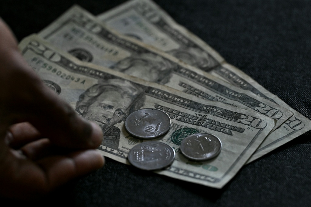 قطع معدنية من عملة الروبية الهندية فوق أوراق نقدية بالدولار الأميركي في مكتب في بنغالورو في 5 كانون الاول/ديسمبر 2025 (ا ف ب)