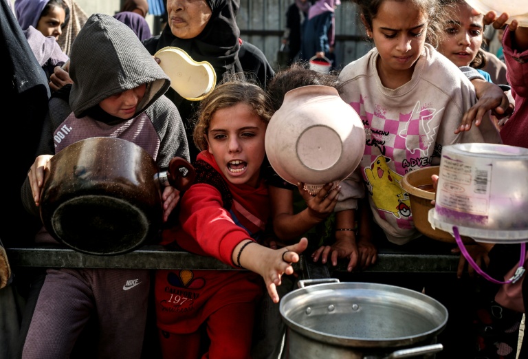 نازحون فلسطينيون يحاولون الحصول على طعام في مخيم النصيرات في غزة في 23 تشرين الثاني/نوفمبر 2025 (أ ف ب)