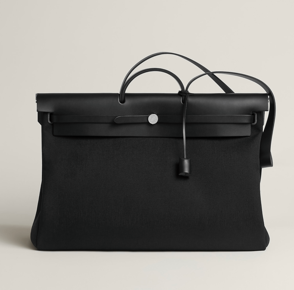 حقيبة Herm&egrave;s Herbag Zip بتصميم أسود أنيق يجمع بين القماش المتين والجلد الناعم، تعكس روح الدار العملية مع لمسة فخامة هادئة تناسب الاستخدام اليومي والسفر - المصدر: Herm&egrave;s 