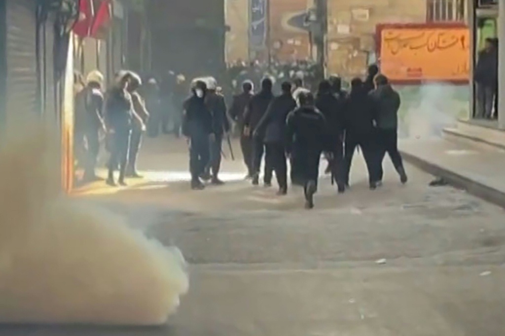 صورة ملتقطة من مقطع فيديو تظهر عناصر من قوات الأمن الإيرانية يستخدمون الغاز المسيل للدموع في بازار طهران في السادس من كانون الثاني/يناير 2026 (ا ف ب)