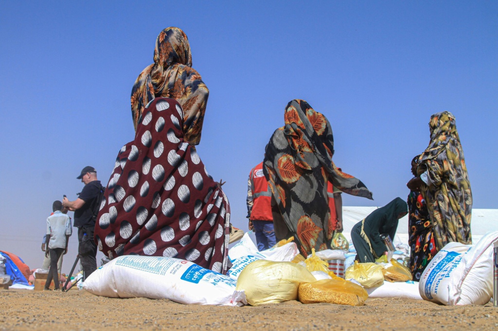 نساء سودانيات هربن من الفاشر يتلقين مساعدات إنسانية في مخيم العفاض للنازحين في مدينة الدبة في شمال السودان في 25 تشرين الثاني/نوفمبر 2025 (ا ف ب)