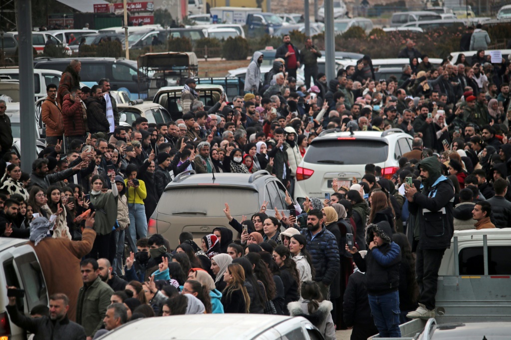مواطنون يتجمعون للترحيب بمركبات تنقل مقاتلين أكراد من مدينة حلب الشمالية إلى مدينة القامشلي الواقعة شمال شرق سوريا والخاضعة لسيطرة الأكراد، في 11 كانون الثاني/يناير 2026 (ا ف ب)