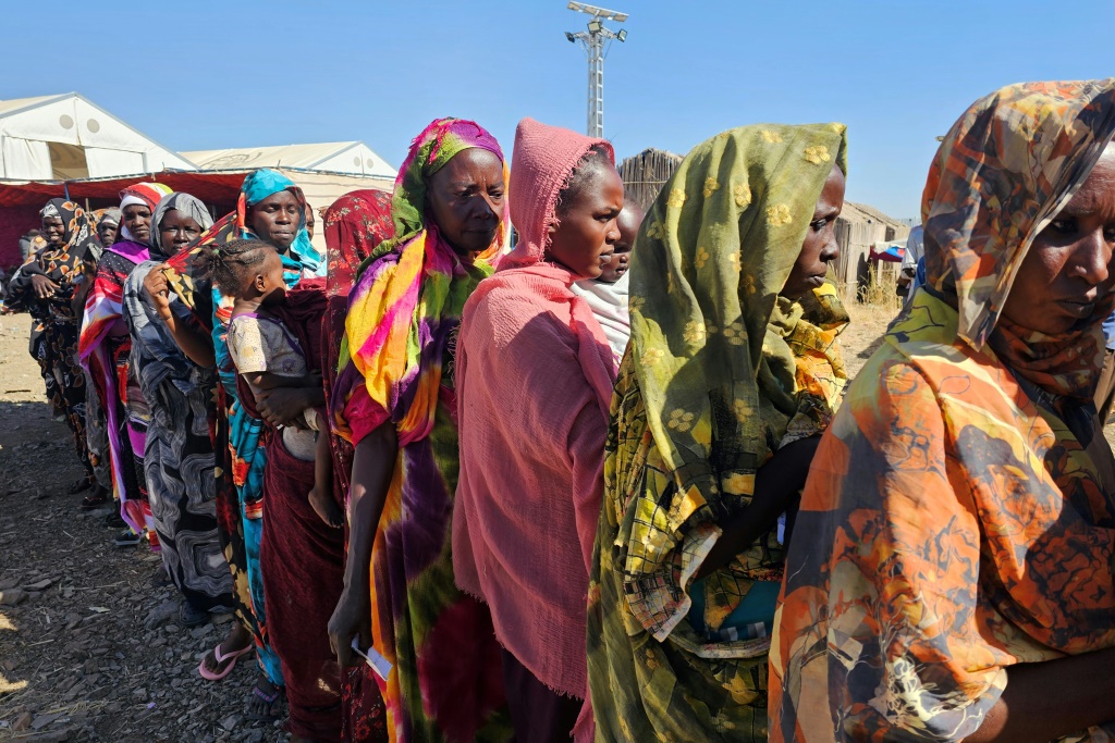نازحات سودانيات من مدينة هجليج على الحدود مع جنوب السودان ينتظرن دورهنّ للحصول على مساعدات إنسانية في مخيّم أبو النجا في ولاية القضارف في 30 كانون الأول/ديسمبر 2025 (ا ف ب)