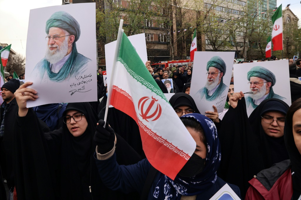 إيرانيون يرفعون صور المرشد الأعلى آية الله علي خامنئي خلال مراسم دفن عناصر من قوات الأمن في طهران في 14 كانون الثاني/يناير 2026 (ا ف ب)
