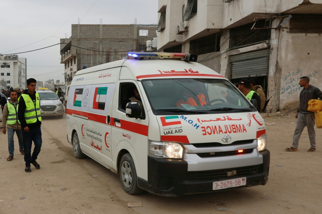 فلسطينيون يعملون مع اللجنة المصرية يقفون الى جانب سيارة اسعاف تنقل جثتين الى مستشفى الشفاء في مدينة غزة في 21 كانون الثاني/يناير 2026 (ا ف ب)