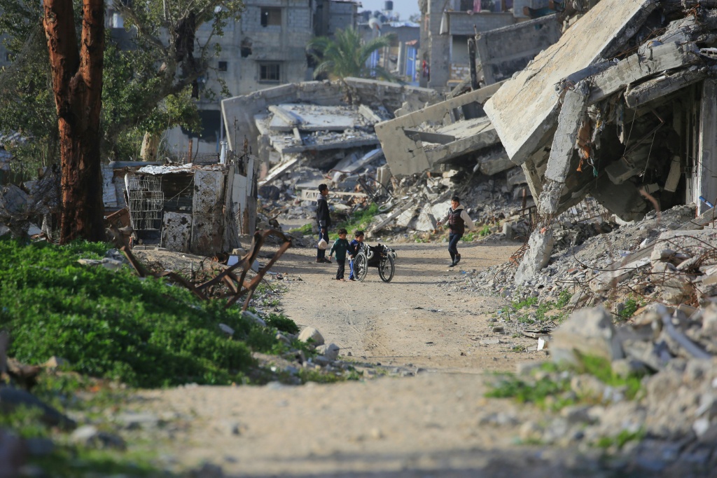 أطفال فلسطينيون يلعبون وسط مبانٍ مدمرة في خان يونس، جنوب قطاع غزة، في 25 كانون الثاني/يناير 2026 (ا ف ب)