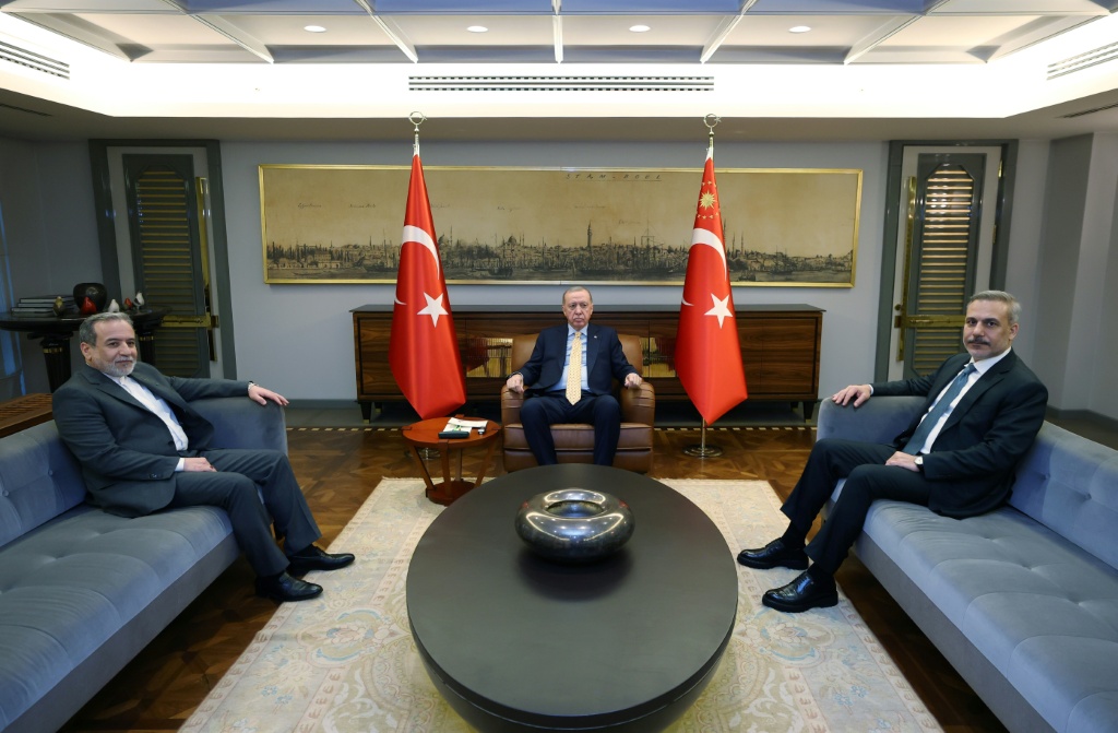 الرئيس التركي رجب طيب إردوغان يتوسط وزير خارجيته هاكان فيدان ووزير الخارجية الإيراني عباس عراقجي في 30 كانون الثاني/يناير 2026 (ا ف ب)