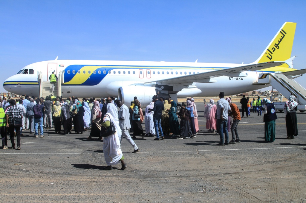 سودانيون يحيطون بطائرة ركاب هبطت في مطار الخرطوم الدولي في الأول من شباط/فبراير 2026 (ا ف ب)