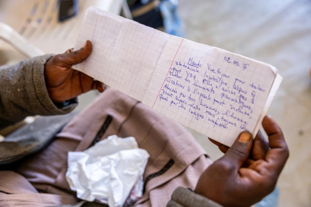 لاجئة سودانية تعرضت للاغتصاب خلال هجوم على مخيم زمزم في السودان تتصفح سجلها الطبي في مخيم للاجئين في شرق تشاد في 31 كانون الثاني/يناير 2026 (ا ف ب)