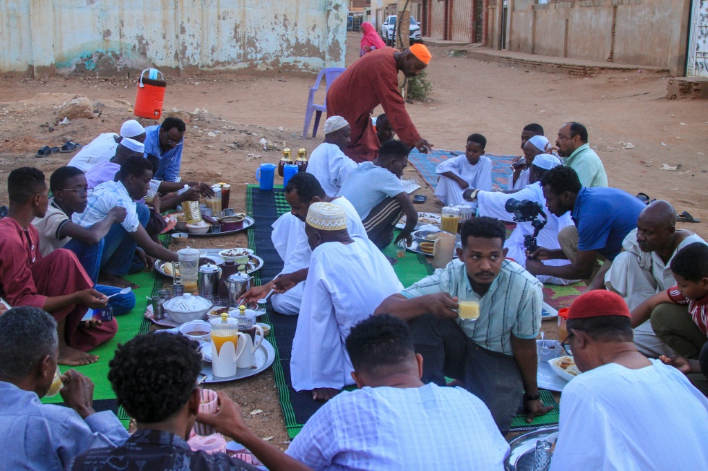 سودانيون يتناولون إفطارا جماعيا في حي الحتانة بأم درمان في أول أيام شهر رمضان في 18 شباط/فبراير 2026 (ا ف ب)
