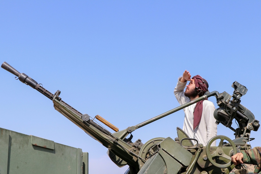 أحد أفراد أمن طالبان بالقرب من مدفع مضاد للطائرات، ويراقب الغارات الجوية الباكستانية قرب خط ديوراند في مديرية غوربوز بولاية خوست في 27 شباط/فبراير 2026، عقب اشتباكات ليلية عبر الحدود بين باكستان وأفغانستان (ا ف ب)