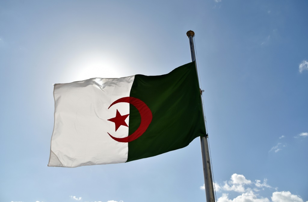 العلم الجزائري منكسا في الجزائر العاصمة في 12 نيسان/أبريل 2018 خلال ثلاثة أيام حداد على ضحايا حادث تحطم طائرة عسكرية في اليوم السابق أسفر عن مقتل 257 شخصا (ا ف ب)