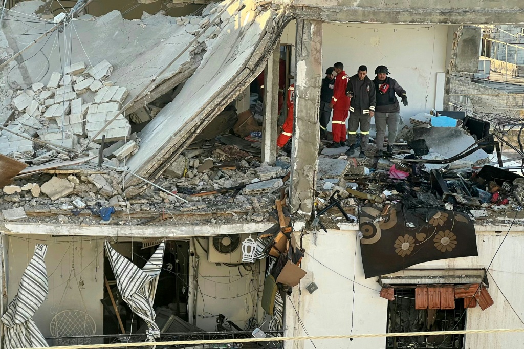 مسعفون يتفقدون موقع غارة في مخيم عين الحلوة في صيدا في جنوب لبنان في 8 آذار/مارس 2026 (ا ف ب)