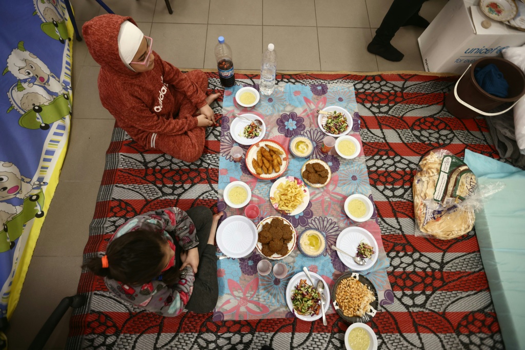 عائلة نازحة تفطر في شهر رمضان في مدرسة تحولت الى ملجأ في السابع من آذار/مارس 2026 (ا ف ب)