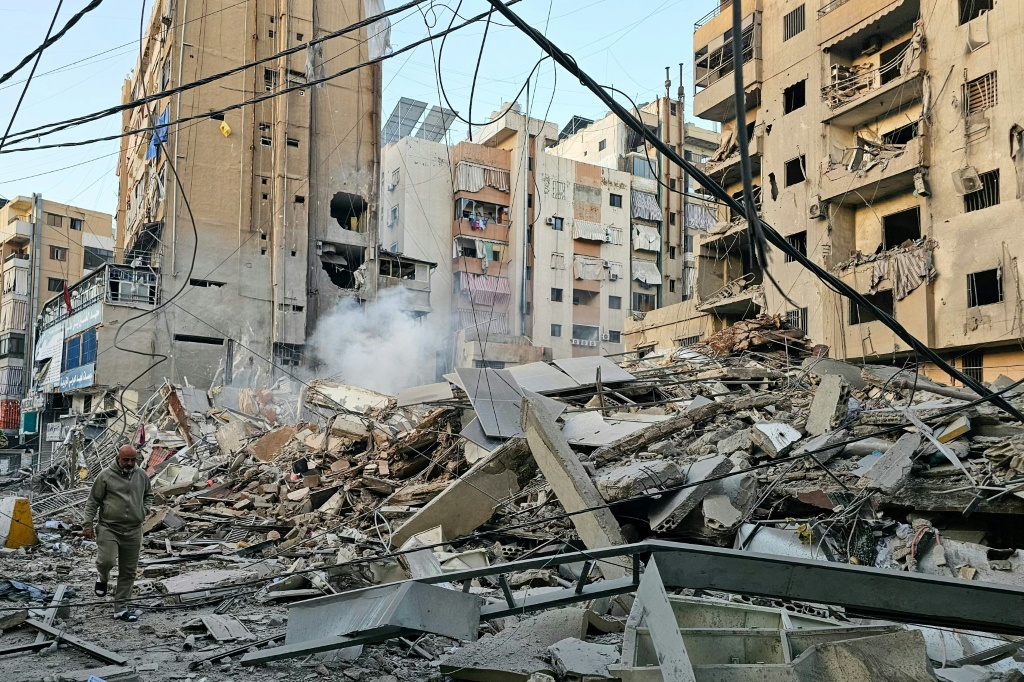 رجل يمشي وسط الركام بعد غارة إسرائيلية على مبنى في بئر العبد بالضاحية الجنوبية لبيروت في 24 آذار/مارس 2026 (ا ف ب)