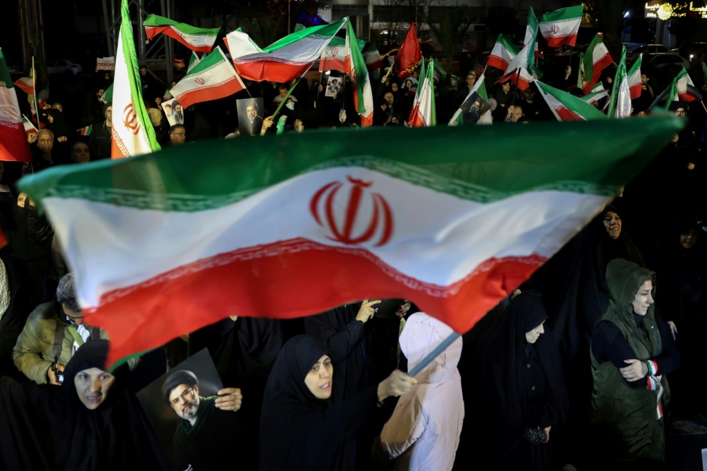 إيرانيون يلوّحون بأعلام بلدهم ويرفعون صور المرشد الأعلى مجتبى خامنئي خلال مسيرة دعما للقوات المسلحة في العاصمة طهران (ا ف ب)