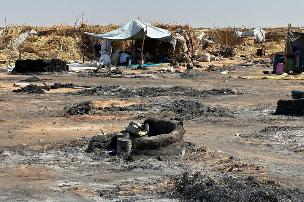 نازحون غادروا الفاشر إثر سيطرة قوات الدعم السريع عليها، وسط بقايا حريق اندلع في مخيم في الطويلة في 11 شباط/فبراير 2026(ا ف ب)