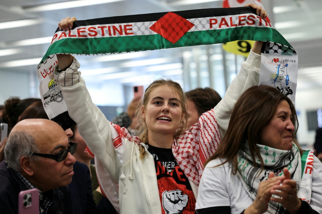 النائبة في البرلمان الأوروبي وعضو حزب "فرنسا الأبية" اليساري إيما فورو (وسط) ترفع وشاحا يحمل العلم الفلسطيني لدى استقبالها من قبل أنصارها في مطار أورلي قرب باريس، في 7 تشرين الأول/أكتوبر 2025 (ا ف ب)