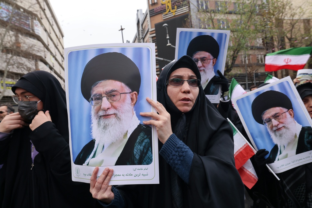 إيرانيون يحملون صورة المرشد الأعلى الإيراني الراحل آية الله علي خامنئي أثناء حضورهم مراسم جنازته (ا ف ب)