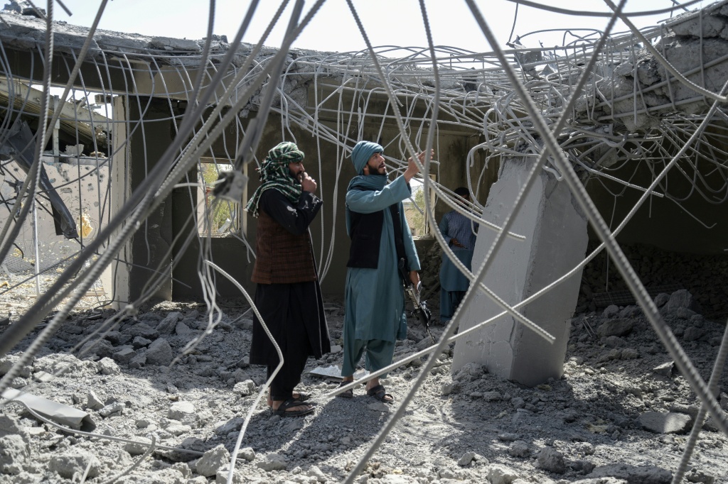 أفراد من قوات الأمن التابعة لحركة طالبان يتفقدون مبنى تضرّر جراء غارة جوية باكستانية في منطقة قندهار، في 15 آذار/مارس 2026 (ا ف ب) 