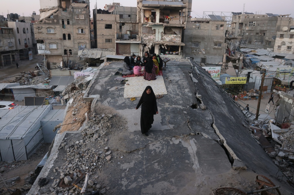 نازحون فلسطينيون على مبنى مدمر جراء القصف الإسرائيلي في خان يونس بتاريخ 10 آذار/مارس 2026 (ا ف ب)