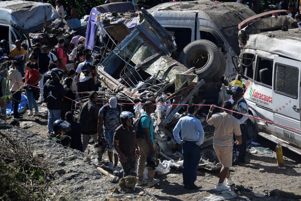 أشخاص يقفون بجانب مركبات دمرها التفجير في إقليم كاوكا في كولومبيا بتاريخ 25 نيسان/أبريل 2026 (ا ف ب)