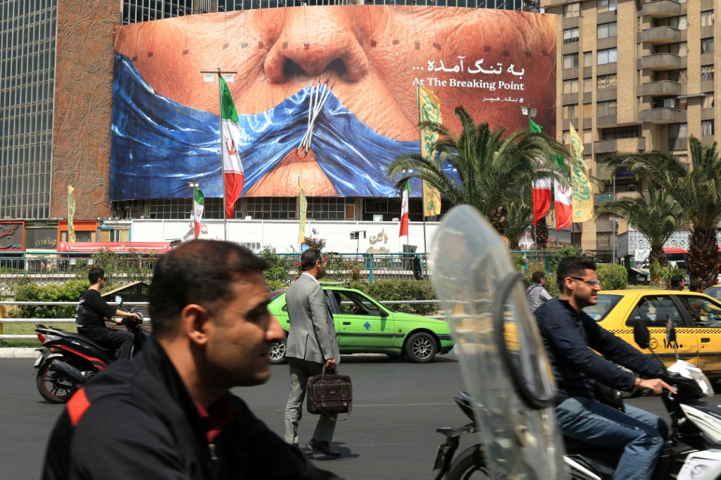 لافتة مناهضة لأميركا تصور الرئيس دونالد ترامب مكبلا عند مضيق هرمز، في طهران، في الثاني من أيار/مايو 2026 (ا ف ب)