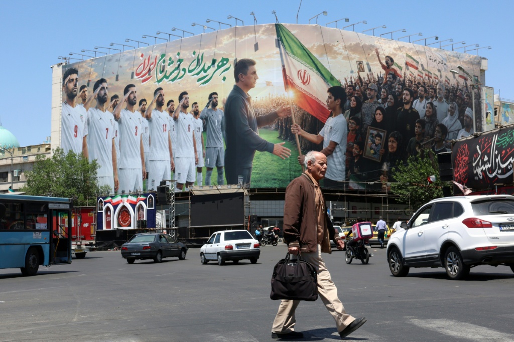 لوحة إعلانية ضخمة دعما للمنتخب الإيراني لكرة القدم في كأس العالم 2026، في ميدان انقلاب (الثورة) في طهران (ا ف ب)