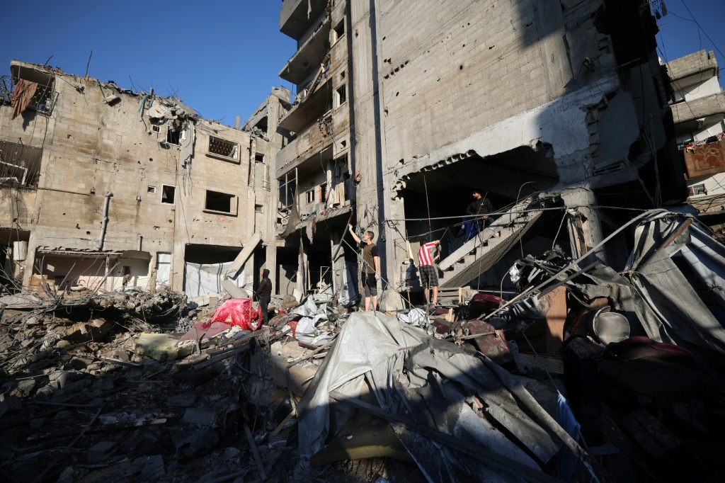 فلسطينيون يتفحصون أنقاض مبنى دمرته غارة إسرائيلة في مخيم النصيرات في وسط قطاع غزة في 23 أيار/مايو 2026 (ا ف ب)