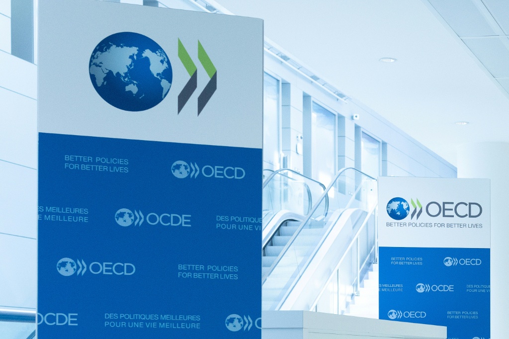 صورة التُقطت في 22 أيلول/سبتمبر 2025، تظهر شعار منظمة التعاون والتنمية في المجال الاقتصادي (OECD) معروضا على لافتات في مقر المنظمة في باريس (ا ف ب)