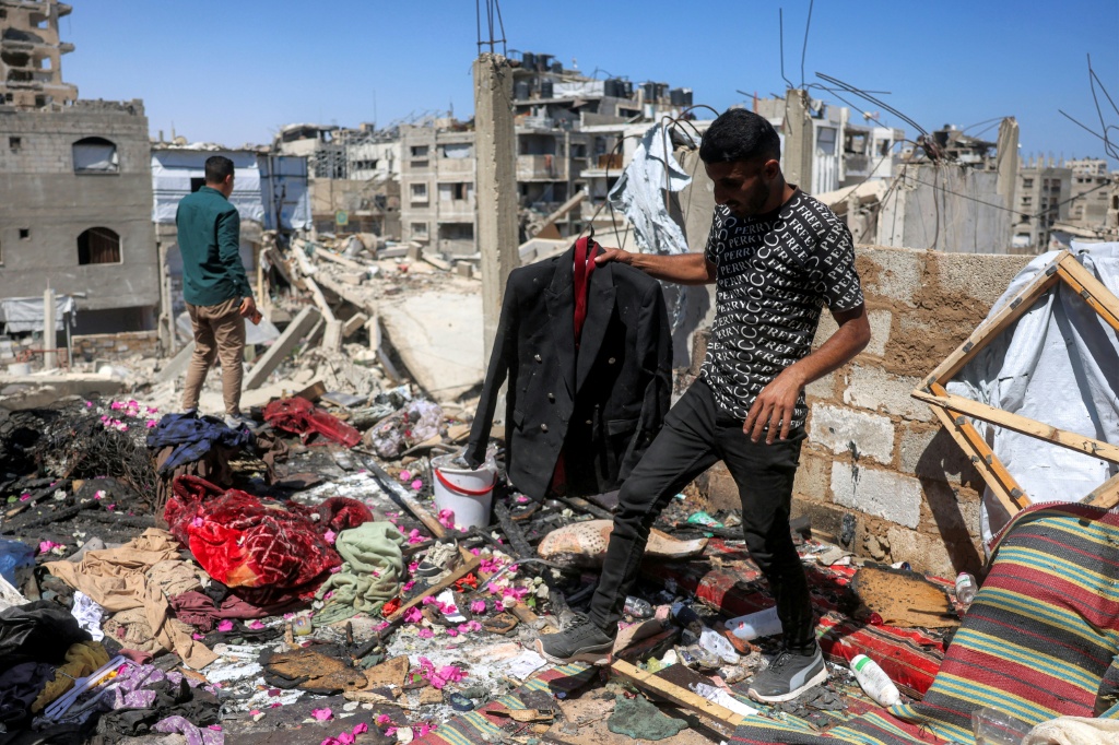 رجل يحمل سترة زفاف الفلسطيني مهند فروانة الذي قُتل إثر قصف إسرائيلي على خيمته عشية زفافه موقع خان يونس بجنوب قطاع غزة في السادس من حزيران/يونيو 2026 (ا ف ب)