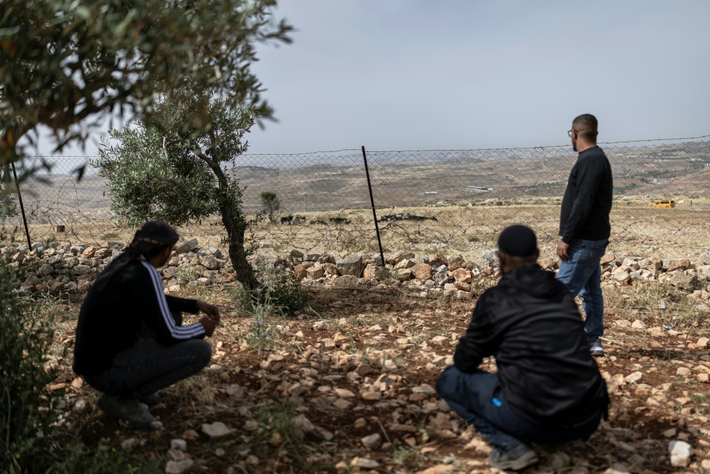 رجال من البدو الفلسطينيين يراقبون مرور قطيع يعود لمستوطن إسرائيلي في تجمع دار أبو فازة قرب قرية الطيبة في الضفة الغربية المحتلة، في 12 أيار/مايو 2026 (ا ف ب)