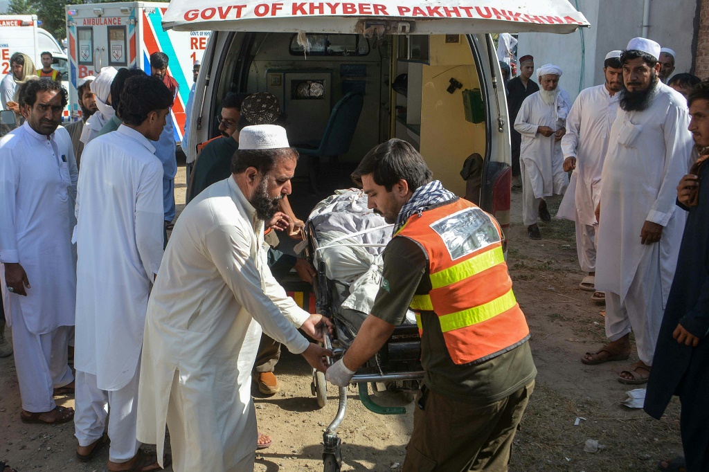 متطوعون ينقلون جثة أحد ضحايا انفجارين متزامنين على جانب الطريق إلى مستشفى في بانو في شمال غرب باكستان في 20 حزيران/يونيو 2026 (ا ف ب)