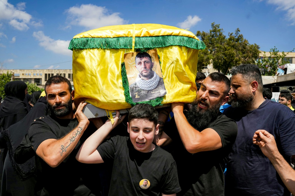 مشيعون يرفعون نعش مقاتل في حزب الله قبيل دفنه في النبطية في جنوب لبنان في 23 حزيران/يونيو 2026 (ا ف ب)