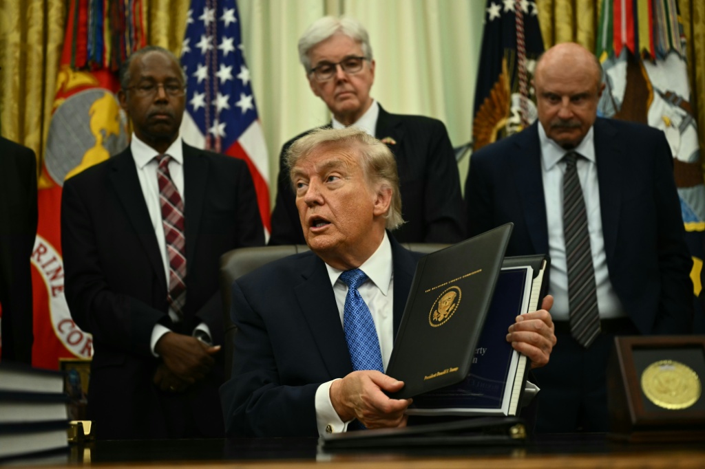 الرئيس الأميركي دونالد ترامب يعرض في المكتب البيضوي في البيت الأبيض في واشنطن في 26 حزيران/يونيو 2026 الخلاصات التي توصلت إليها لجنة الحريات الدينية (ا ف ب)