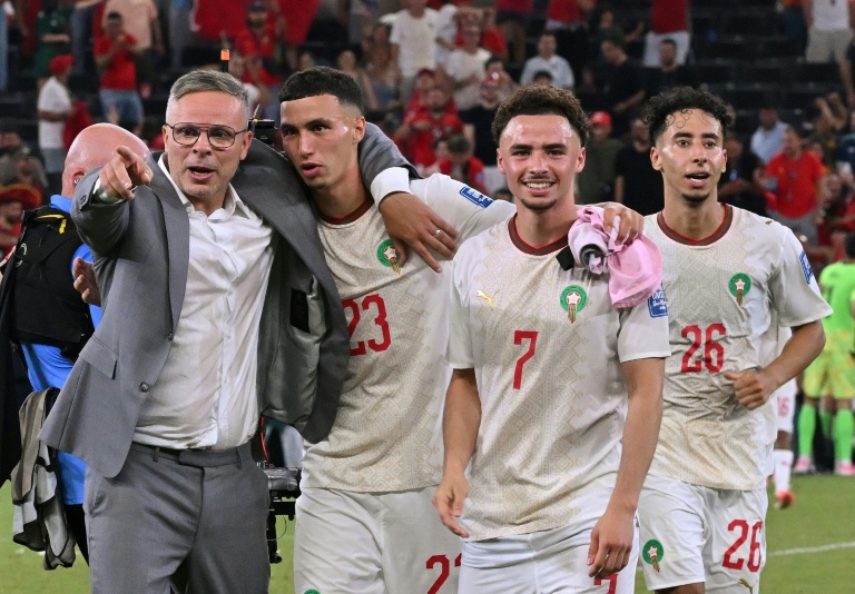مدرب المغرب محمد وهبي (يسار) يحتفل مع لاعبي المغرب بعد التأهل إلى ثمن نهائي مونديال 2026 على حساب هولندا (أ ف ب)