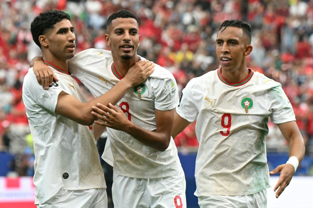 لاعب الوسط المغربي عز الدين أوناحي (وسط) يحتفل بتسجيله الهدف الأول في مرمى كندا (3-0) مع زميليه المدافع أشرف حكيمي (يسار) والمهاجم سفيان رحيمي (يمين) خلال الدور ثمن النهائي لكأس العالم في أميركا الشمالية في هيوستن في 4 تموز/يوليو 2026 (ا ف ب)