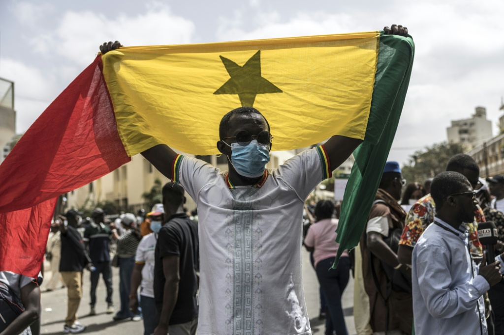 سنغالي يلوّح بعلم بلده خلال تظاهرة قرب مقر الجمعية الوطنية في دكار في 29 حزيران/يونيو 2026، احتجاجا على مشروع قانون لتعديل الدستور (ا ف ب)