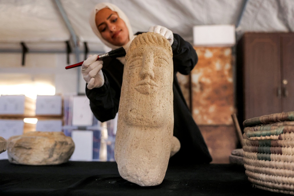 متطوعة في جمعية مياسم للثقافة والفنون تصلح قطعة أثرية في خانيونس في 11 تموز/يوليو 2026 (ا ف ب)