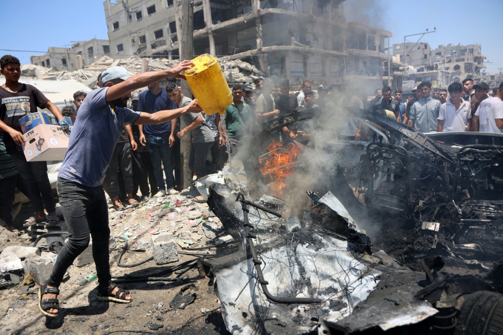 فلسطيني يحاول إخماد حريق في مركبة بموقع غارة إسرائيلية في مدينة غزة في 20 تموز/يوليو 2026 (ا ف ب)